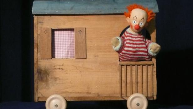 Der kleine Clown schaut aus dem Wohnwagen