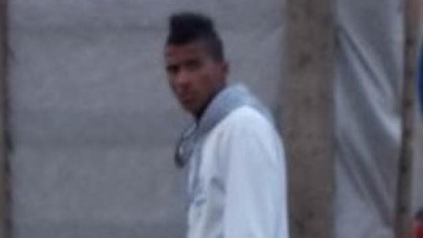 Ein junger Mann mit Irokesenschnitt blickt in die Kamera.