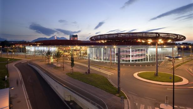 Das Design Center Linz mit beleuchteter Fassade in der Abenddämmerung.