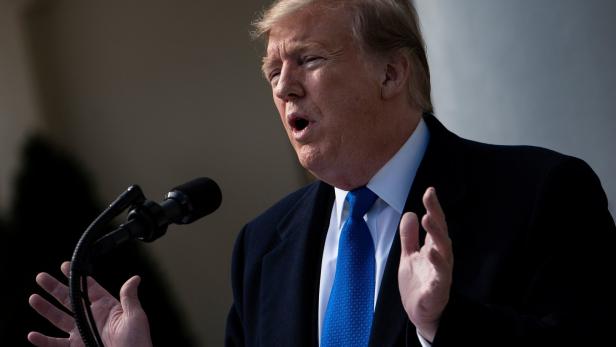 Donald Trump spricht bei einer Rede vor einem Mikrofon.