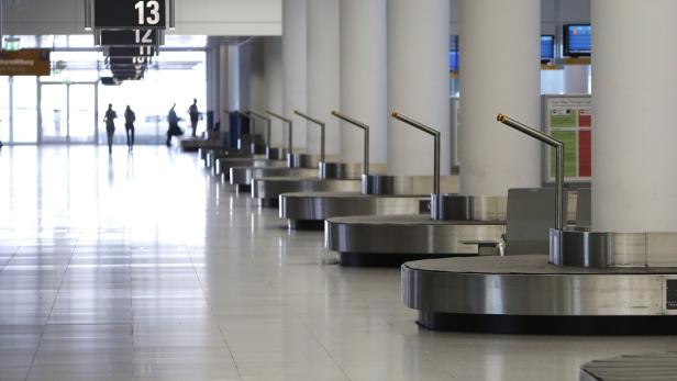 Eine Reihe von Gepäckbändern in einem hellen, modernen Flughafen.