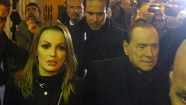 epa03503299 Italian former Prime Minister Silvio Berlusconi (2nd R) walks with Francesca Pascale (2nd L), signaled in certain circles as his girlfriend, after a Pdl (People of Freedom) party meeting in Milan, Italy, 09 December 2012. Berlusconi has ended weeks of speculation by announcing he will run again for prime minister, the position to which he was forced to resign in 2011. EPA/STEFANO PORTA
