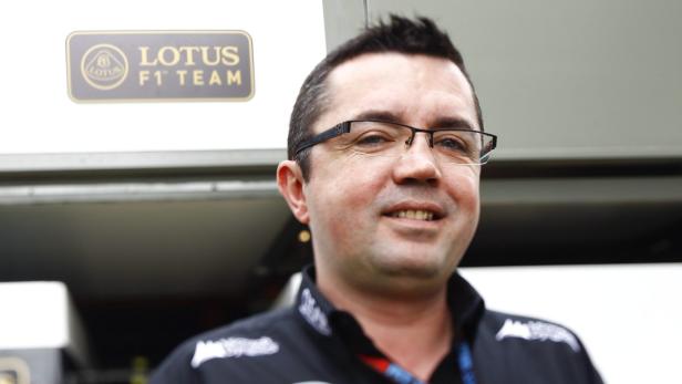 Ein Mann mit Brille und einem Lotus F1 Team Logo im Hintergrund.