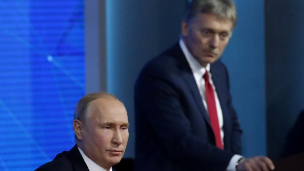 Kremlin spokesman Peskov listens as Russian President Putin speaks during annual news conference in Moscow