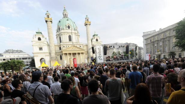 Eine Menschenmenge versammelt sich vor der Karlskirche in Wien für das Popfest.