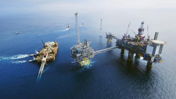 Luftaufnahme von mehreren Ölplattformen auf dem offenen Meer.