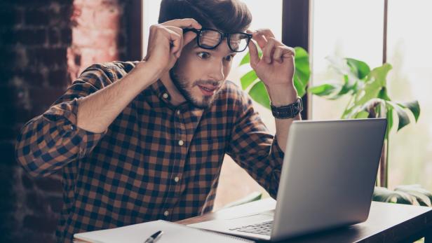 Erstaunter Mann am Notebook.