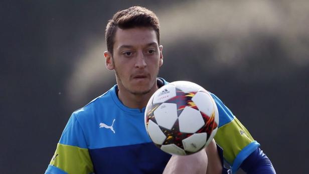 Mesut Özil jongliert mit einem Fußball.