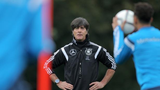 Joachim Löw, der ehemalige Trainer der deutschen Nationalmannschaft, steht mit verschränkten Armen da.