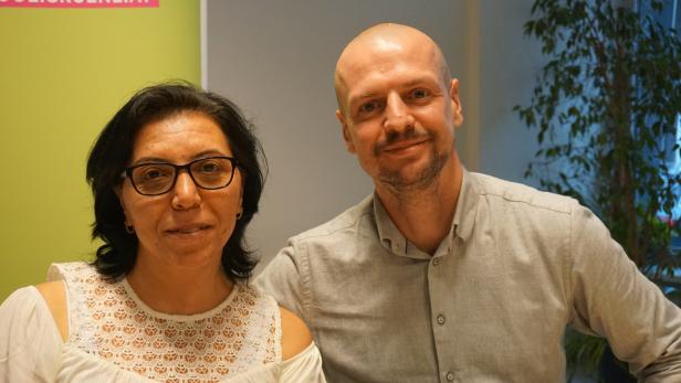 Eine Frau mit Brille und ein Mann mit Hemd posieren für ein Foto.