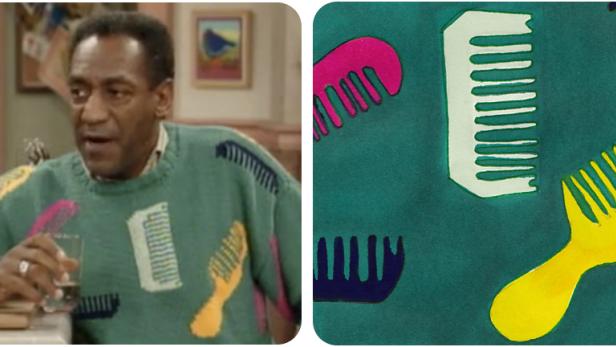 Ein Mann mit einem bunten Pullover mit Kamm-Motiven hält ein Glas.