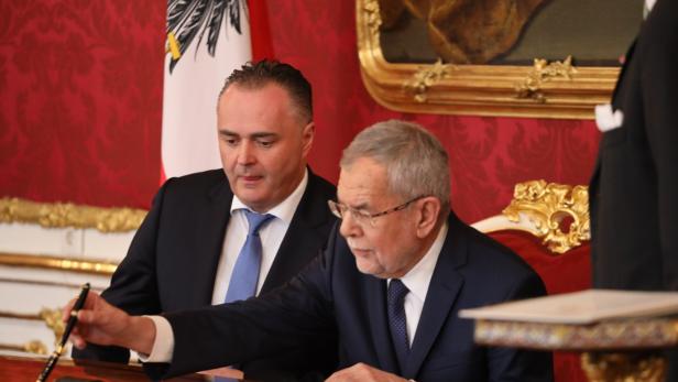 Bundespräsident Alexander Van der Bellen unterzeichnet ein Dokument.