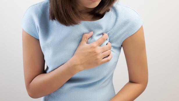 Woman holding her chest fearing a heart attack