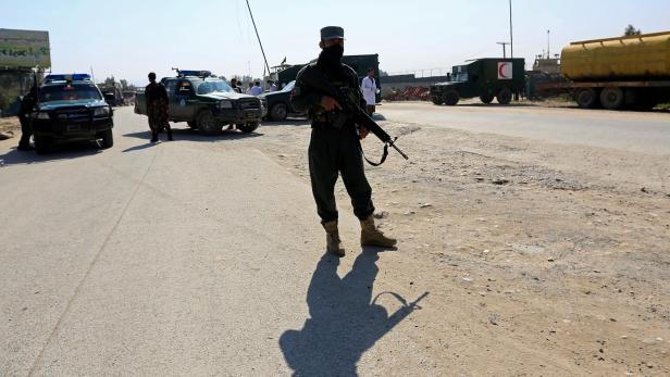 Afghan security forces stand guard near the site of an attack in Jalalabad