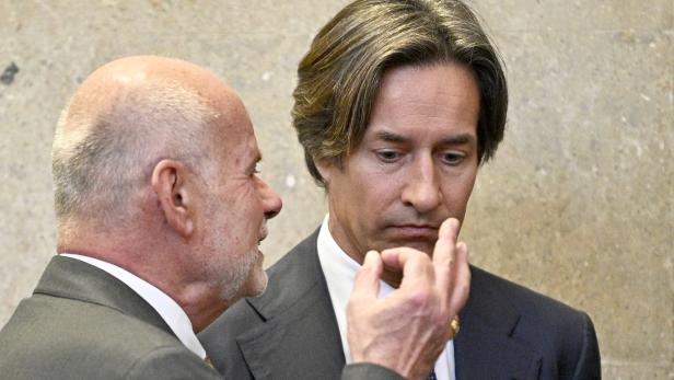 Zwei Männer in Anzügen unterhalten sich angeregt.