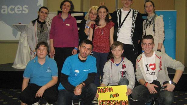 Eine Gruppe von Personen posiert mit einem Schild mit der Aufschrift „Bosnien und Herzegowina“.