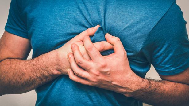Ein Mann greift sich zum Herzen. 