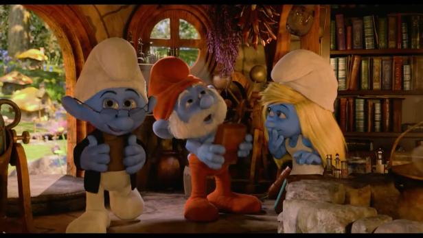 Drei Schlümpfe stehen in einem Raum mit Büchern und Gerätschaften.