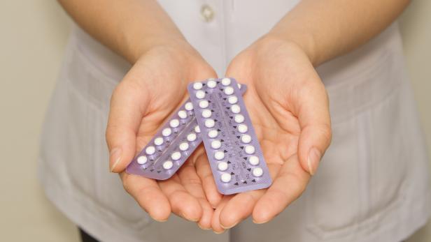 doctor's hand  holding the birth control pills