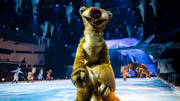 Sid, das Faultier aus „Ice Age“, steht auf einer Eisfläche während einer Bühnenaufführung.