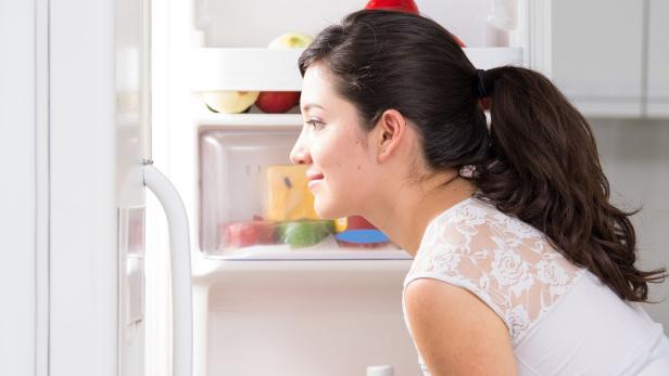 young beautiful woman searching for food in the fridge
