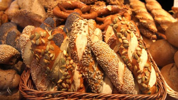 Verschiedene Brotsorten und Brezeln in einem geflochtenen Korb.