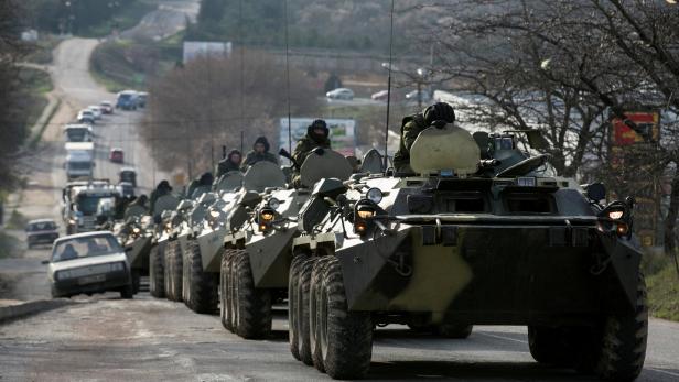 FILE PHOTO: Soldiers ride on military armoured personnel carriers on a road near the Crimean port city of Sevastopol