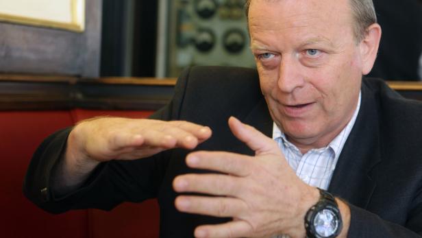 Ein Mann in einem Anzug gestikuliert mit seinen Händen.