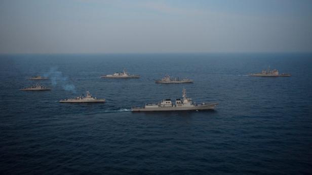 Mehrere Kriegsschiffe fahren auf dem offenen Meer.