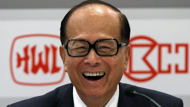 Li Ka-shing lächelt vor einem Hintergrund mit dem Hutchison Whampoa-Logo.