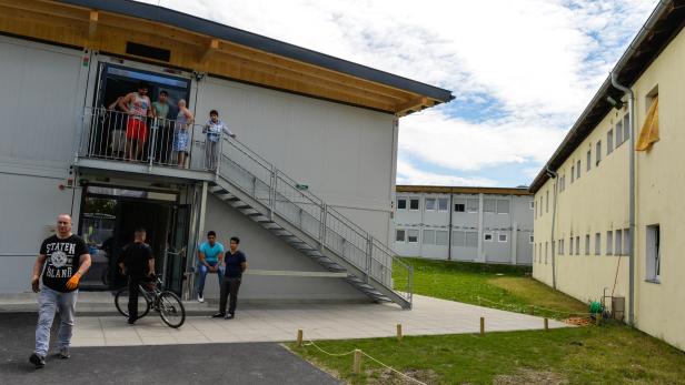 Mehrere Personen stehen vor einem Gebäude mit Treppe.