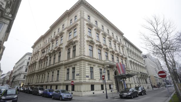 Ein großes, verziertes Gebäude in Wien mit der österreichischen Flagge vor dem Eingang.