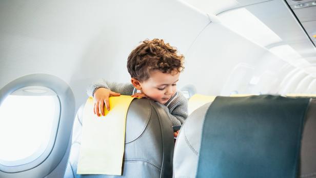 Boy playing with toy plane in airplane