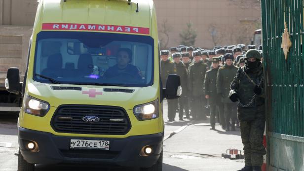 An ambulance passes servicemen leaving Alexander Mozhaysky Military Space Academy after a blast injured several people, according to officials cited by Russian media