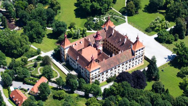 Luftaufnahme von Schloss Eggenberg in Graz, umgeben von grünen Gärten und Bäumen.