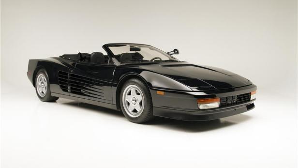 Ein schwarzer Ferrari Testarossa Spider vor einem neutralen Hintergrund.