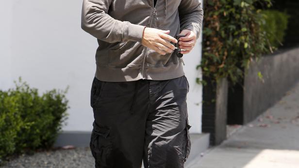 Matt Damon in Shorts und Kapuzenpullover geht die Straße entlang.