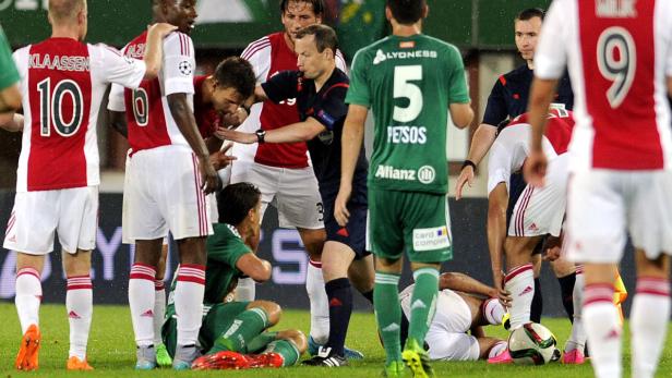 Ein Fußballspiel mit Spielern in roten und grünen Trikots und einem Schiedsrichter.