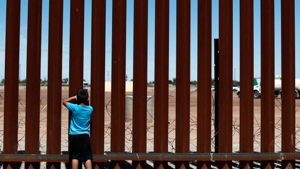 A child looks through the border wall during the visit of U.S. President Donald Trump to Calexico, California, as seen in Mexicali