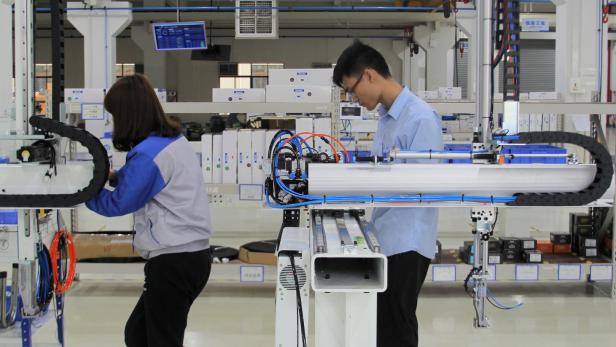 Chinesische Arbeiter in einem Industrie-Roboter-Testgelände