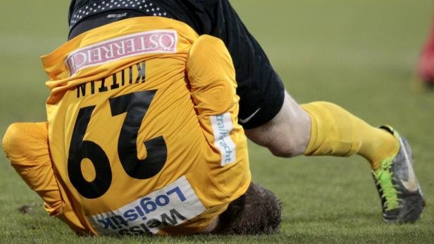Ein Fußballspieler mit der Nummer 62 liegt auf dem Rasen.