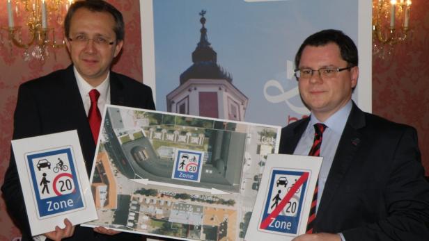Zwei Männer präsentieren Schilder und einen Plan für eine Tempo-20-Zone.