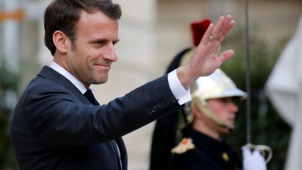 French President Emmanuel Macron waves to Ukrainian President Petro Poroshenko as he leaves the Elysee Palace in Paris