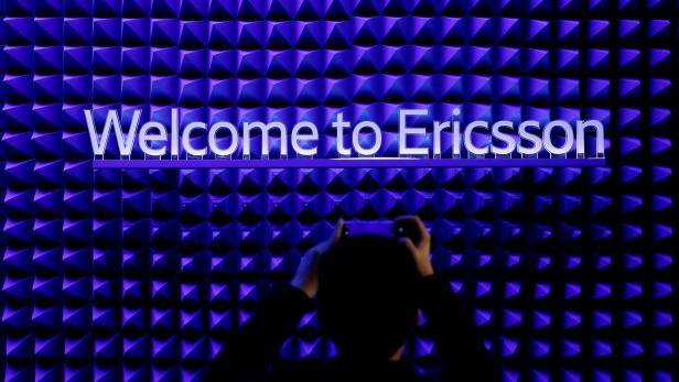 FILE PHOTO: A visitor takes a picture with his mobile phone in front of the Ericsson booth at the Mobile World Congress in Barcelona