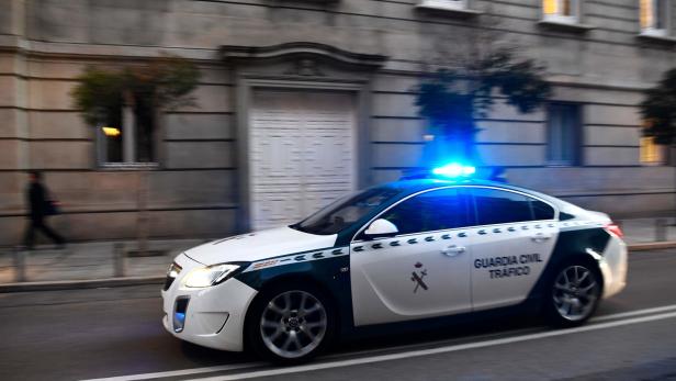 Ein Streifenwagen der Guardia Civil fährt mit Blaulicht durch eine Stadt.