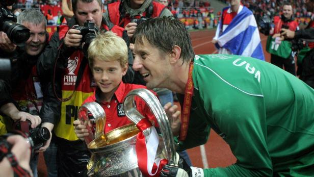 epa01353285 Manchester United goalkeeper Edwin van der Sar and his son Joe pose with the trophy after the UEFA Champions League final between Manchester United and FC Chelsea at the Luzhniki stadium in Moscow, Russia, 21 May 2008. EPA/YURI KOCHETKOV NO MOBILE PHONE DEVICES