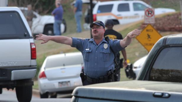 epa03657295 A police officer clears the path for a Gwinnett County Fire Rescue ambulance after a hostage situation ended with a barricaded gunman holding five firefighters hostage inside Walnut Grove subdivision in Suwanee, Georgia, USA, 10 April 2013. All hostages were safely rescued in an operation that killed the gunman. EPA/AKILI-CASUNDRIA RAMSESS