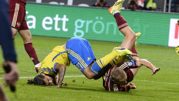 Zwei Fußballspieler fallen während eines Spiels zu Boden.