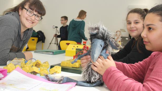 Jugendliche bauen Stromkreise puzzleartig zusammen - mit dabei Maskottchen Gudrun
