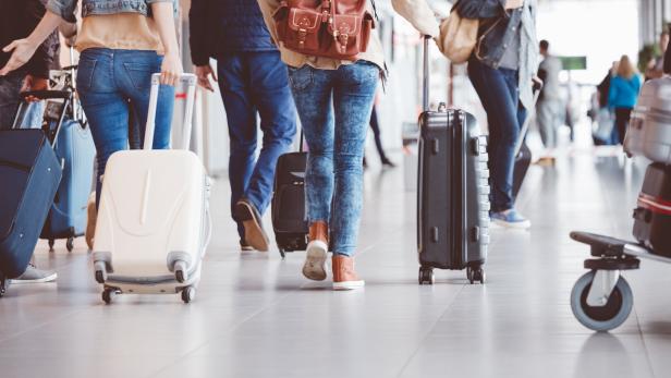 Passagiere gehen im Flughafenterminal entlang.